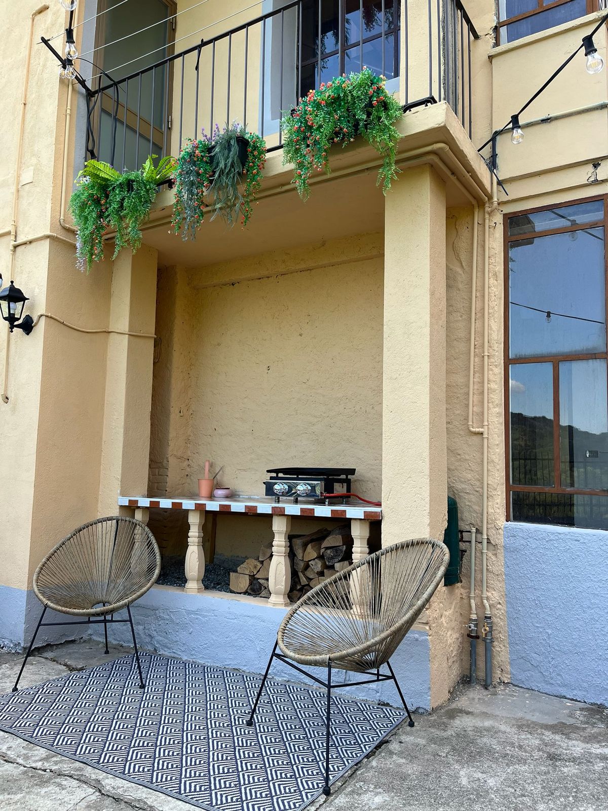 Voorkant van het huis met balkon en hangplanten